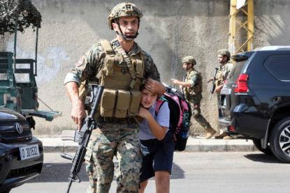 يحمل بندقيته بيمينه ويحتضن طفلة بيساره: صورة المعاون أول بلال الحاج من أجمل صور العالم للعام 2021 